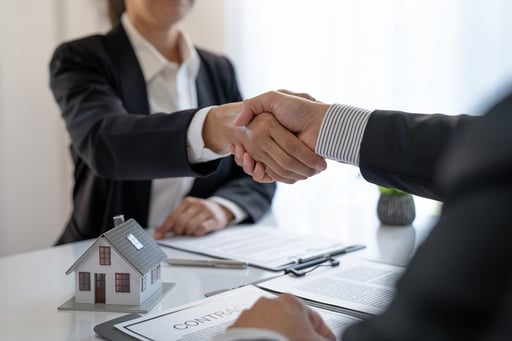 Broker shaking hand with client over home contract