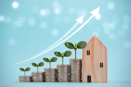Leaves on top of coin stacks with line graph growing next to model of home
