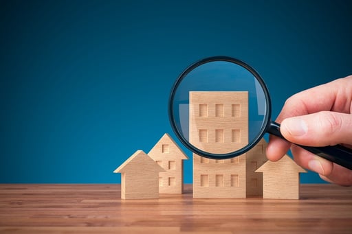 Magnifying glass focused on wood models of real estate