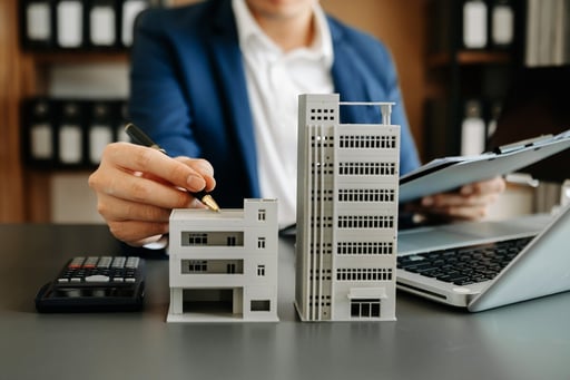 Agent pointing to multifamily house models with pen