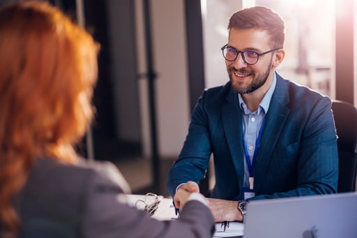 Broker shaking hands with a client after a successful deal