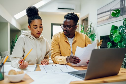 couple looking into the blueprints of a home