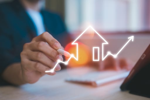 man using computer working with virtual chart of real estate growth overlayed
