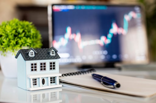 House model pen and notepad on table with stock market chart